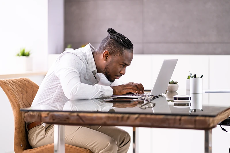 a man with poor posture looking at his computer